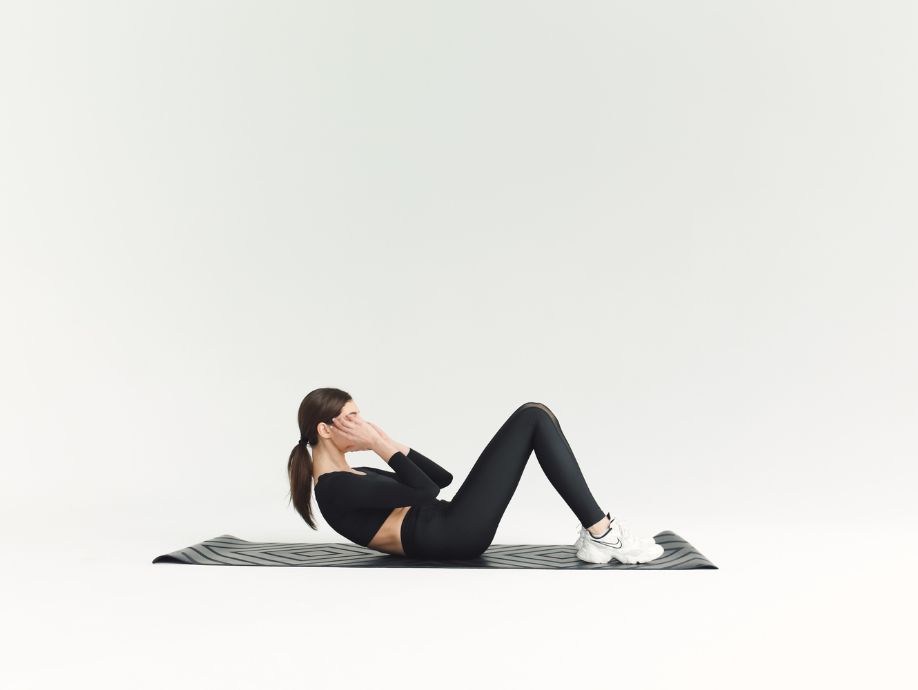 a woman doing crunches in a fitness studio